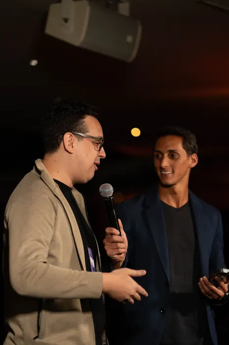 Dois convidados conversam no palco com microfone